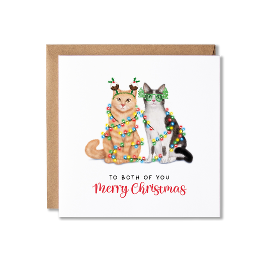 Christmas card with illustration of a cat couple, a ginger cat and grey and white cat, sat together wrapped in Christmas lights with the message To Both of You Merry Christmas.