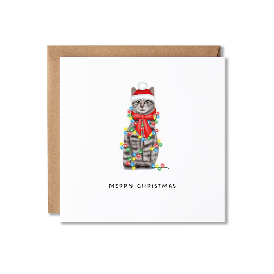 Christmas card with illustration of a grey tabby cat wrapped in Christmas lights with the message Merry Christmas underneath.