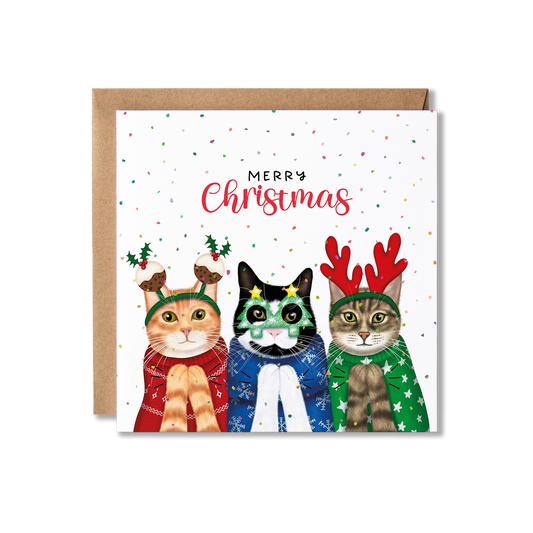 Christmas card with illustration of three cats in Christmas jumpers, one red and wearing christmas pudding bobblers, one blue and wearing Christmas tree glasses and one green and wearing red antlers, clapping with the message Merry Christmas.