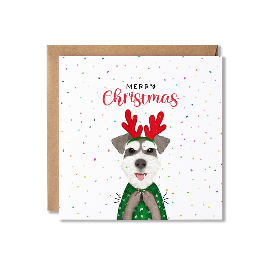 Christmas card with illustration of a Schnauzer dog in a green Christmas jumper and wearing red antlers, clapping with the message Merry Christmas.