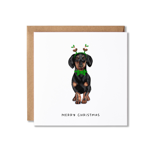 Christmas card with illustration of a Dachshund sausage dog in a green bow tie and Christmas pudding bobblers with the message Merry Christmas.