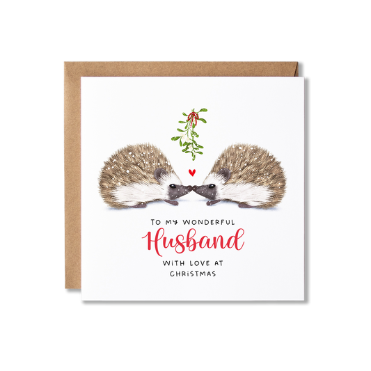 Christmas card with illistration of a couple of hedgehogs sitting underneath some springs of mistletoe tied in a red ribbon with a small red heart shape between them, with the message To My Wonderful Husband.