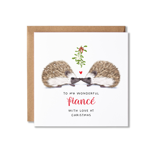 Christmas card with illistration of a couple of hedgehogs sitting underneath some springs of mistletoe tied in a red ribbon with a small red heart shape between them, with the message To My Wonderful Fiance.