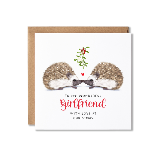 Christmas card with illistration of a couple of hedgehogs sitting underneath some springs of mistletoe tied in a red ribbon with a small red heart shape between them, with the message To My Wonderful Girlfriend.