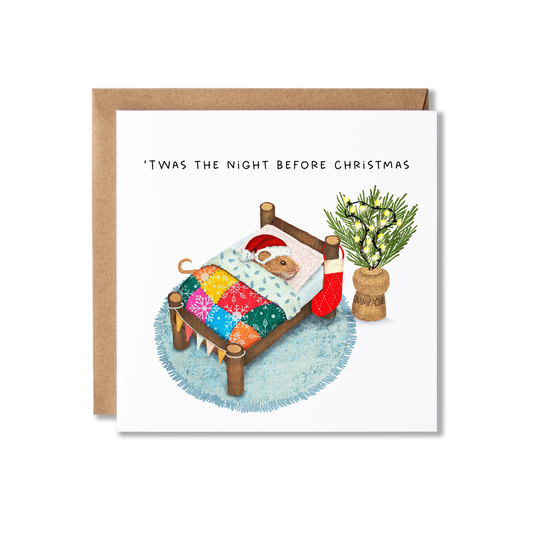 Christmas card with illustration of a mouse wearing a Santa hat in a bed with a colourful blanket lying next to a cork that has sprigs of Christmas tree and festoon lights in it, with the message T'was the Night before Christmas.