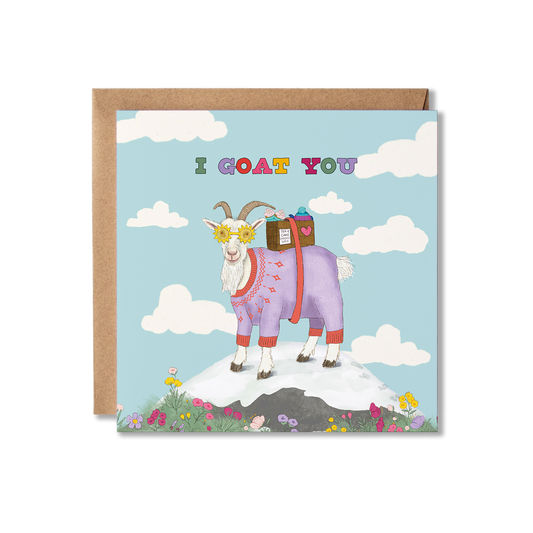 Illustration of a goat on top of a mountain in the middle of a blue sky with clouds around it, wearing a purple jumper and yellow sunshine glasses on, carrying a box of tea and cakes. The multi coloured words, I goat you, is written above. Thinking of You greeting card.