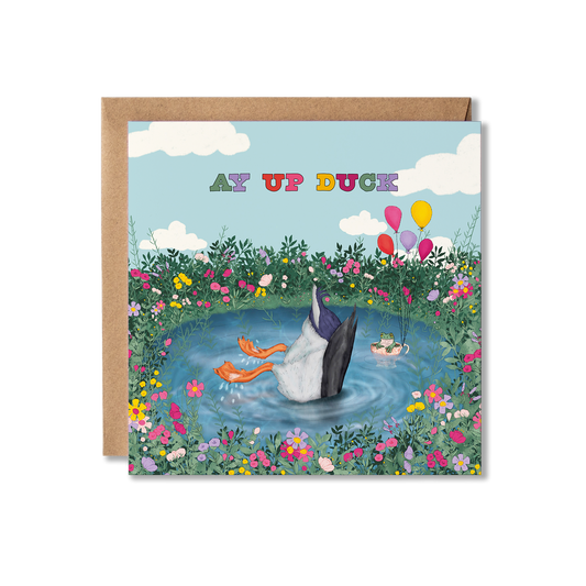Greeting card with an upside down duck in a pond, surrounded by flowers and frog in a tea cup with balloons and the text Ay Up Duck.