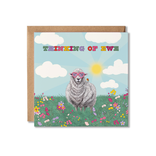 Card with a sheep wearing heart shape glasses in a field of flowers and clouds, with 'Thinking of Ewe' text.