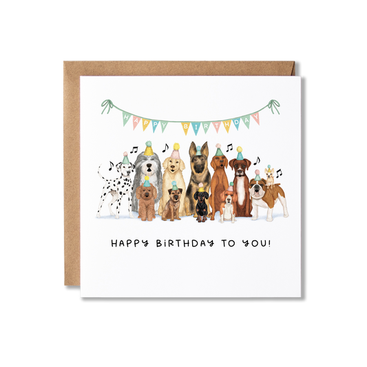 Birthday card with illustration of a group of dogs sat in a row wearing party hats and colourful bunting above them with Happy Birthday on, singing, with the message Happy Birthday to you.
