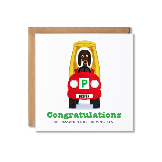Congratulations card with illustration of red and yellow car with dog sitting in the driving seat with the message Congratulations on Passing You Driving Test.