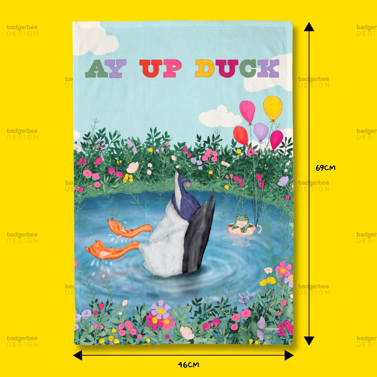 A rectangular printed tea towel featuring a whimsical illustration of a duck standing in water with orange feet, surrounded by flowers, balloons, and the text 'AY UP DUCK' at the top. The item is centered on a bright yellow background with black dimension arrows and labels showing 69 cm height and 46 cm width.