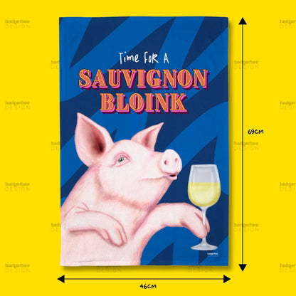 A rectangular printed tea towel with an illustration of a pig holding a glass of white wine on a blue striped background, with the text 'Time FOR A SAUVIGNON BLOINK.' The image includes dimension arrows and labels showing 69 cm height and 46 cm width, set against a bright yellow background with repeated 'Badgefree' watermarks.