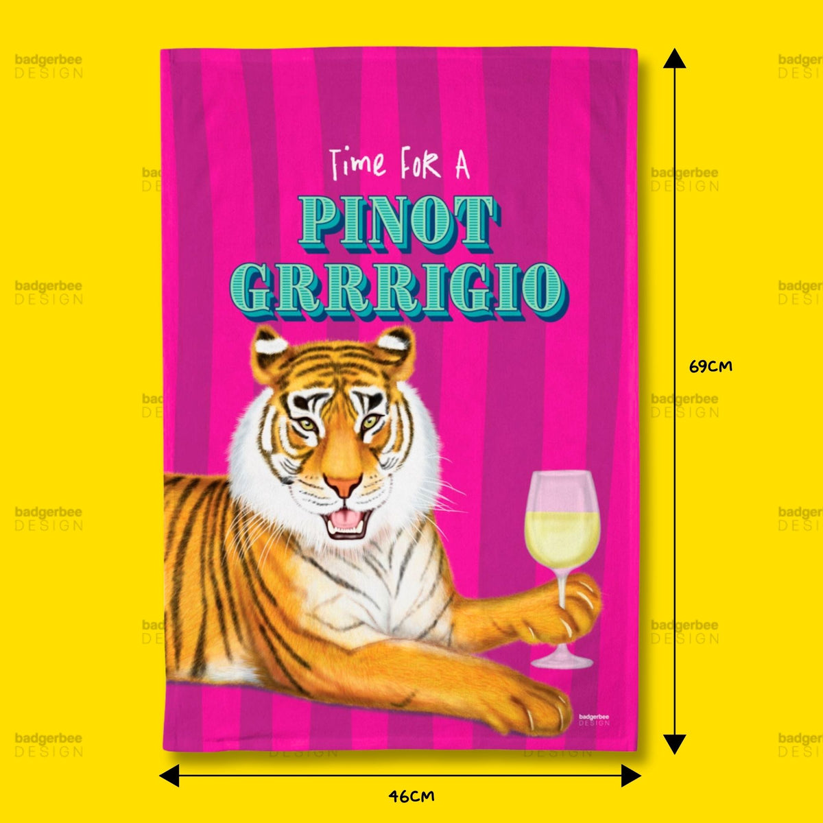 A rectangular printed tea towel with a bright pink striped background, featuring the text 'Time FOR A PINOT GRRIGGIO' above an illustration of a tiger holding a wine glass. Black arrows and labels indicate dimensions of 69 cm height and 46 cm width, set against a solid yellow background.