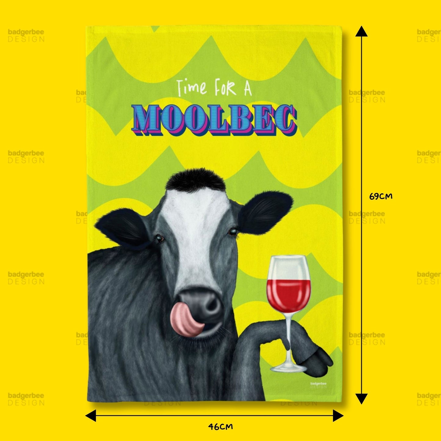A rectangular printed tea towel featuring an illustration of a cow holding a glass of red wine, with the text 'Time FOR A MOOLBEC' on a bright yellow background. Black dimension arrows and labels indicate 69 cm height and 46 cm width.