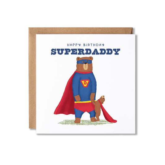 A square birthday card with a kraft envelope behind it, featuring an illustration of a bear dressed as Superman, holding hands with a bear cub, and the text 'HAPPY BIRTHDAY SUPERDADDY' on a white card.