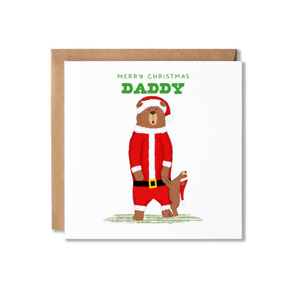 A square Christmas greeting card with a kraft envelope behind it. The card features an illustration of a teddy bear dressed in a Santa-style suit holding hands with a bear cub, with the text 'MERRY CHRISTMAS DADDY' above.