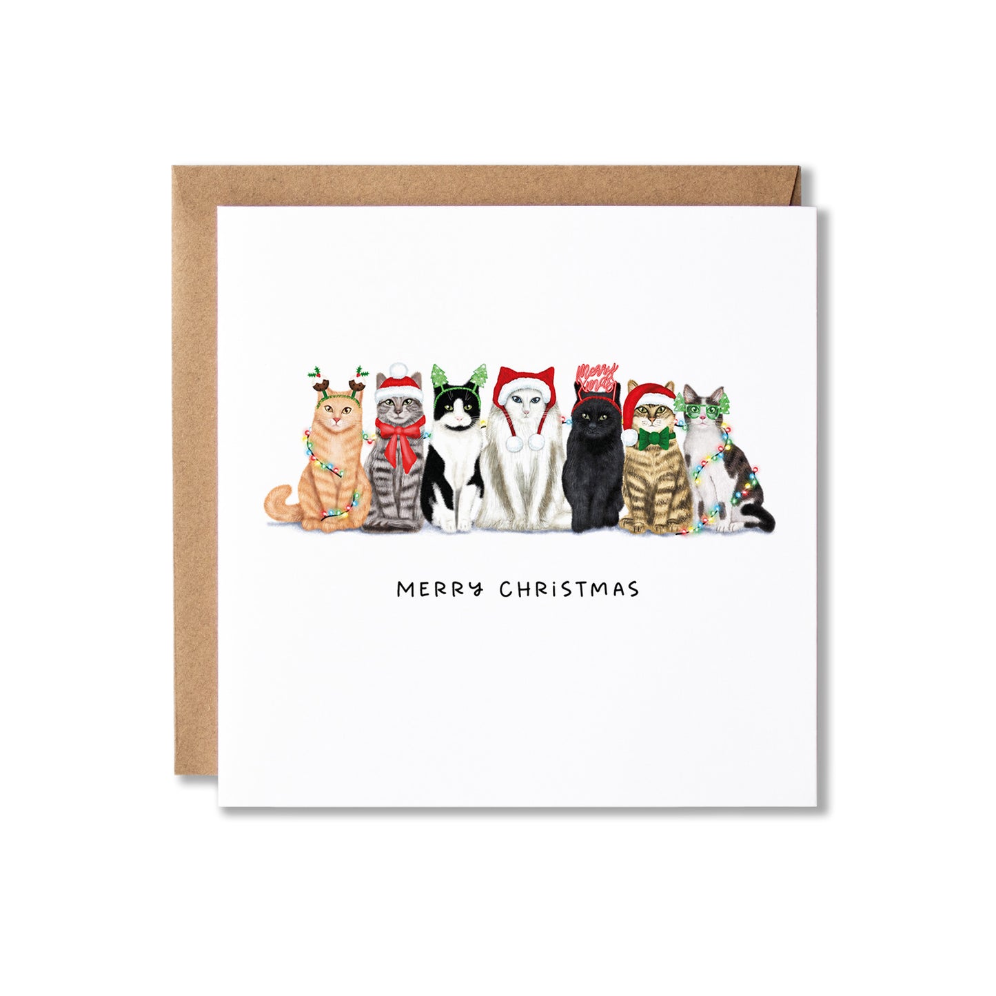 A square white Christmas greeting card with a brown kraft envelope behind it, featuring an illustration of seven cats wearing festive holiday hats and scarves, with the text 'MERRY CHRISTMAS' below.