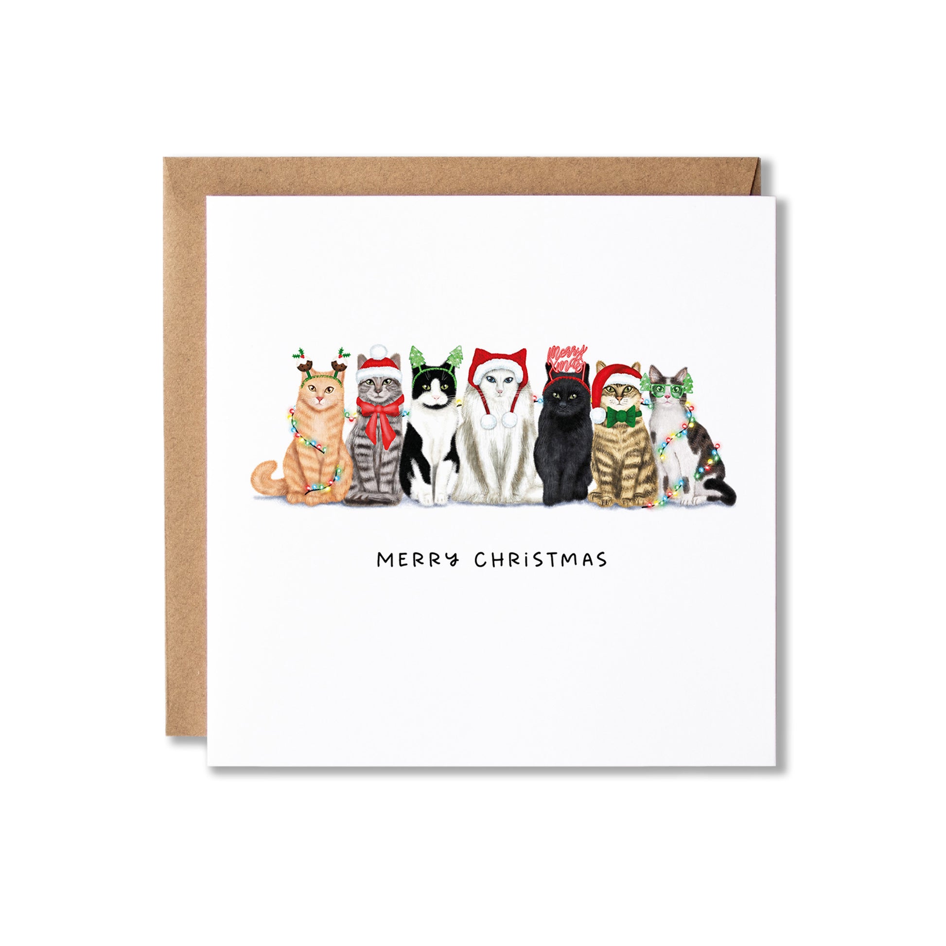A square white Christmas greeting card with a brown kraft envelope behind it, featuring an illustration of seven cats wearing festive holiday hats and scarves, with the text 'MERRY CHRISTMAS' below.