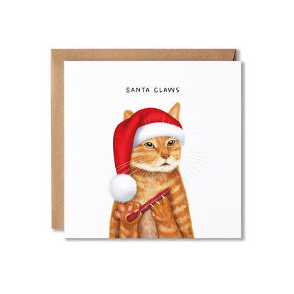 A square greeting card with a brown kraft envelope behind it, featuring an illustration of an orange tabby cat wearing a red Santa hat filing it's claws on a nail file, with the text 'SANTA CLAWS' above.