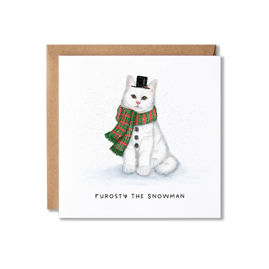 A square greeting card with a kraft envelope behind it, featuring an illustration of a white cat dressed as a snowman with a red and green plaid scarf and small black top hat. The card reads 'FUROSTY THE SNOWMAN' at the bottom.