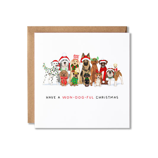 A square Christmas greeting card with a brown kraft envelope behind it. The card features an illustration of multiple dog breeds wearing Santa hats and holiday outfits, with the text 'HAVE A WON-DOG-UL CHRISTMAS' printed below.