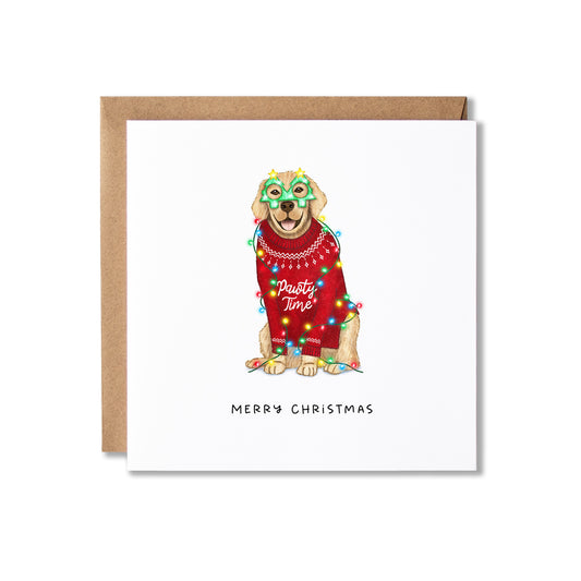 A square white Christmas greeting card with a kraft envelope behind it, featuring an illustrated dog wearing a red sweater, colorful holiday lights, and a green mask, with the text 'MERRY CHRISTMAS' below.