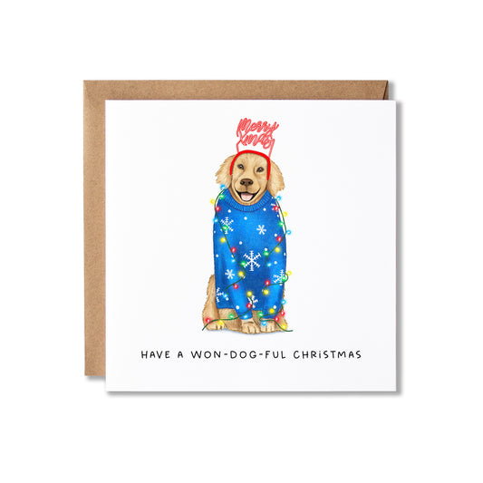 A square Christmas greeting card with a brown kraft envelope behind it. The card features an illustration of a golden retriever wearing a blue holiday sweater with snowflakes and colorful Christmas lights, topped with a red 'Merry Christmas' hat.