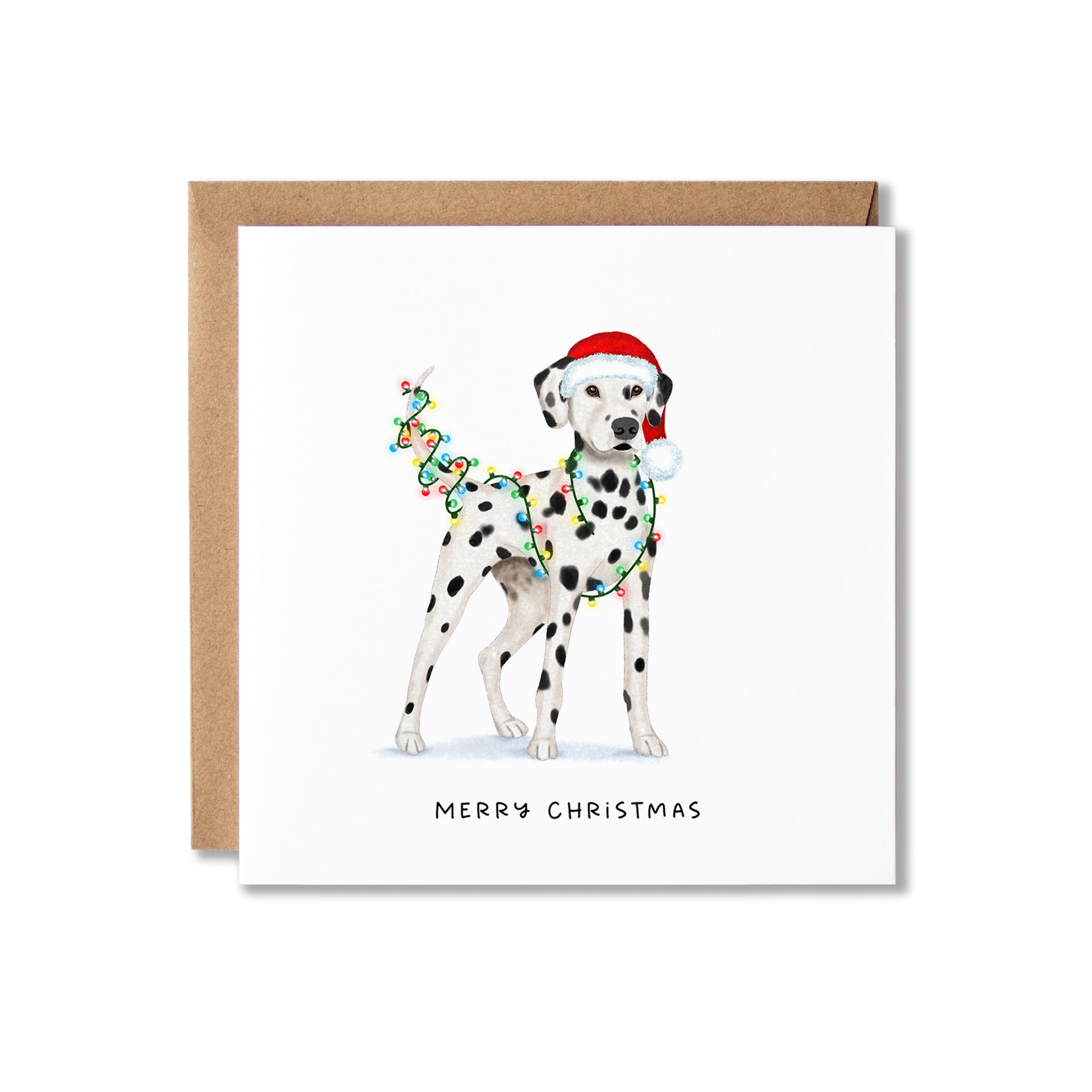 A square Christmas greeting card featuring an illustration of a Dalmatian wearing a Santa hat and a colourful garland, with the text 'MERRY CHRISTMAS' below. The card is shown with a brown kraft envelope behind it on a light grey background.