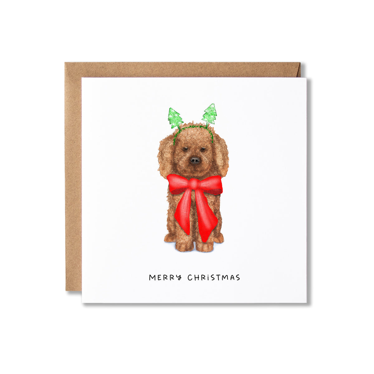 A square Christmas greeting card with a brown kraft envelope behind it. The card features a watercolor illustration of a brown dog wearing green leaf antlers and a large red bow, with the text 'MERRY CHRISTMAS' printed below.