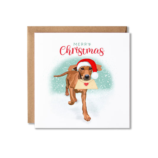 A square Christmas greeting card with a kraft envelope behind it. The card features an illustration of a brown dog wearing a red Santa hat and carrying a cream-colored envelope with a red heart, with the text 'Merry Christmas' above.