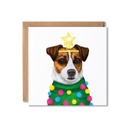 A square greeting card with a brown kraft envelope, featuring an illustration of a Jack Russell dog dressed in a green Christmas sweater with colourful pom-poms and a gold star on its head, set against a plain white background.