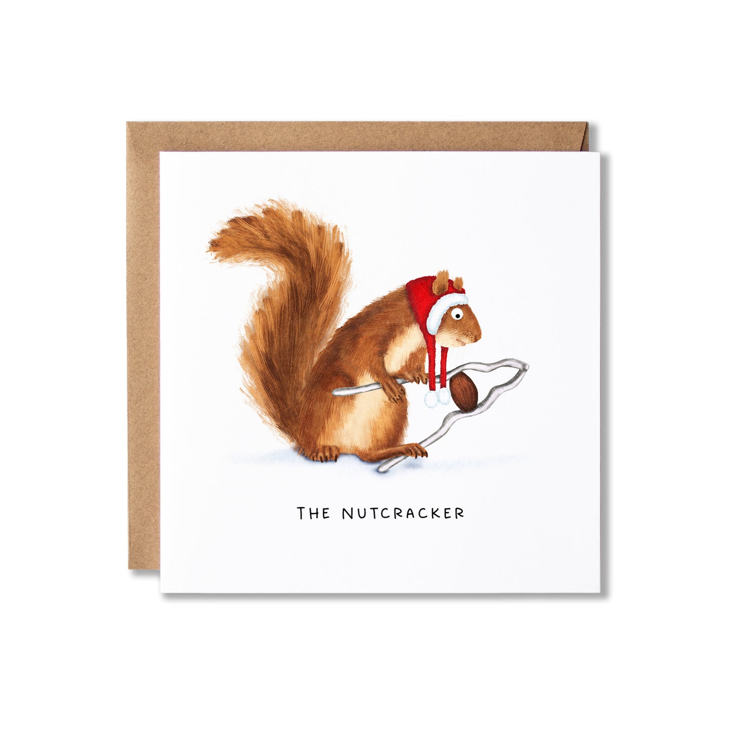 A square greeting card with a brown kraft envelope behind it, featuring an illustration of a squirrel wearing a red Santa hat and scarf while holding a nut, with the text 'THE NUTCRACKER' below.