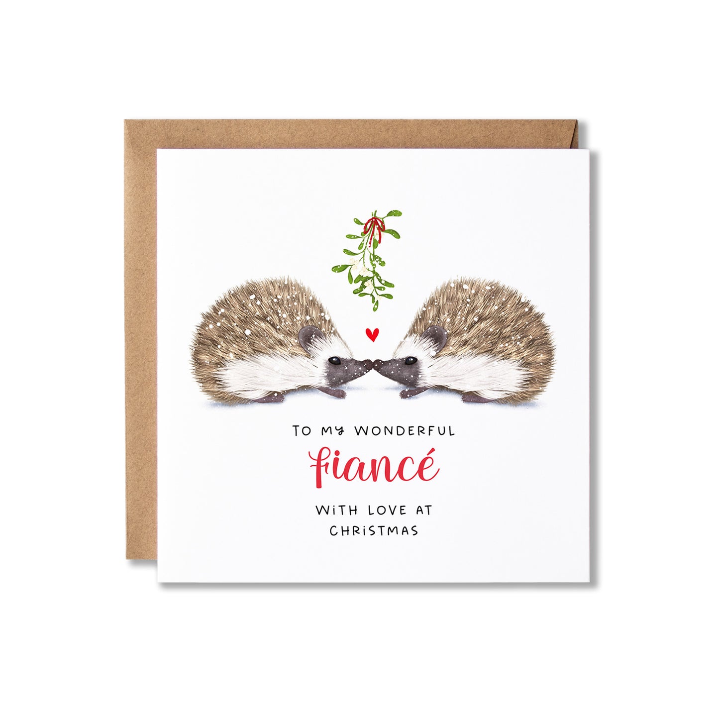 A square Christmas greeting card with a kraft envelope behind it. The card features an illustration of two hedgehogs facing each other with a small red heart and mistletoe between them, above the text 'TO MY WONDERFUL fiancé WITH LOVE AT CHRISTMAS' in black and red lettering on a white background.