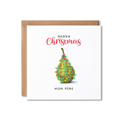 A square white Christmas greeting card with a kraft envelope behind it. The card reads 'Merry Christmas' in red script and 'Mon Père' in black text, with a decorated pear illustration in the center.