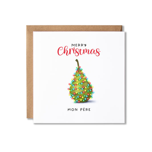 A square white Christmas greeting card with a kraft envelope behind it. The card reads 'Merry Christmas' in red script and 'Mon Père' in black text, with a decorated pear illustration in the center.