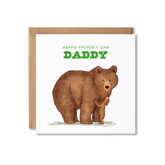 A square birthday card with a kraft envelope behind it, featuring an brown bear illustration and a little bear cub at it's feet looking up and the green text 'HAPPY BIRTHDAY DADDY' on a white card background.