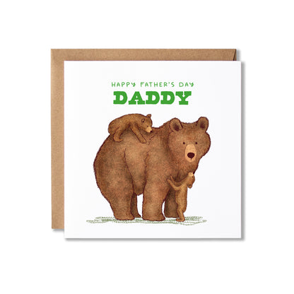 A square Father's Day greeting card with a kraft envelope behind it. The card features an illustration of a brown bear carrying a small cub on its back and one at it's feet, with the text 'HAPPY FATHER'S DAY DADDY' in green at the top.
