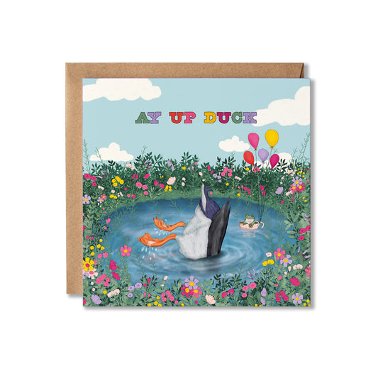A square illustrated Greeting card with an upside down duck in a pond, surrounded by flowers and frog in a tea cup with balloons and the text Ay Up Duck.