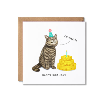 A square birthday card with a brown kraft envelope, featuring an illustration of a grinning tabby cat wearing a party hat next to a yellow cake of cheese with a candle. The card reads 'CHEEEEEEEESE' and 'HAPPY BIRTHDAY'.