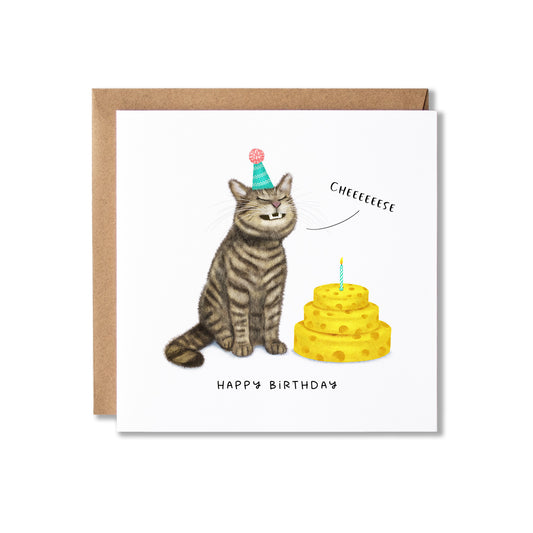 A square birthday card with a brown kraft envelope, featuring an illustration of a grinning tabby cat wearing a party hat next to a yellow cake of cheese with a candle. The card reads 'CHEEEEEEEESE' and 'HAPPY BIRTHDAY'.