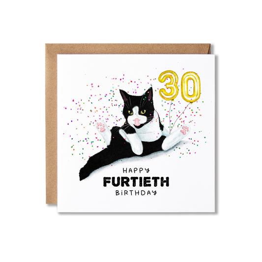 A square birthday card with a kraft envelope behind it, featuring a watercolor-style black-and-white cat lying down with a gold '30' balloon and confetti, plus the text 'HAPPY FURTIETH BIRTHDAY'.