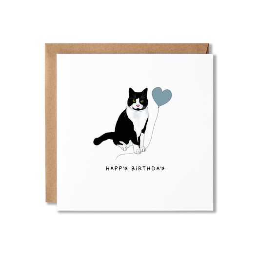 Birthday card with illustration of a black and white tuxedo cat holding a blue balloon and the message Happy Birthday.