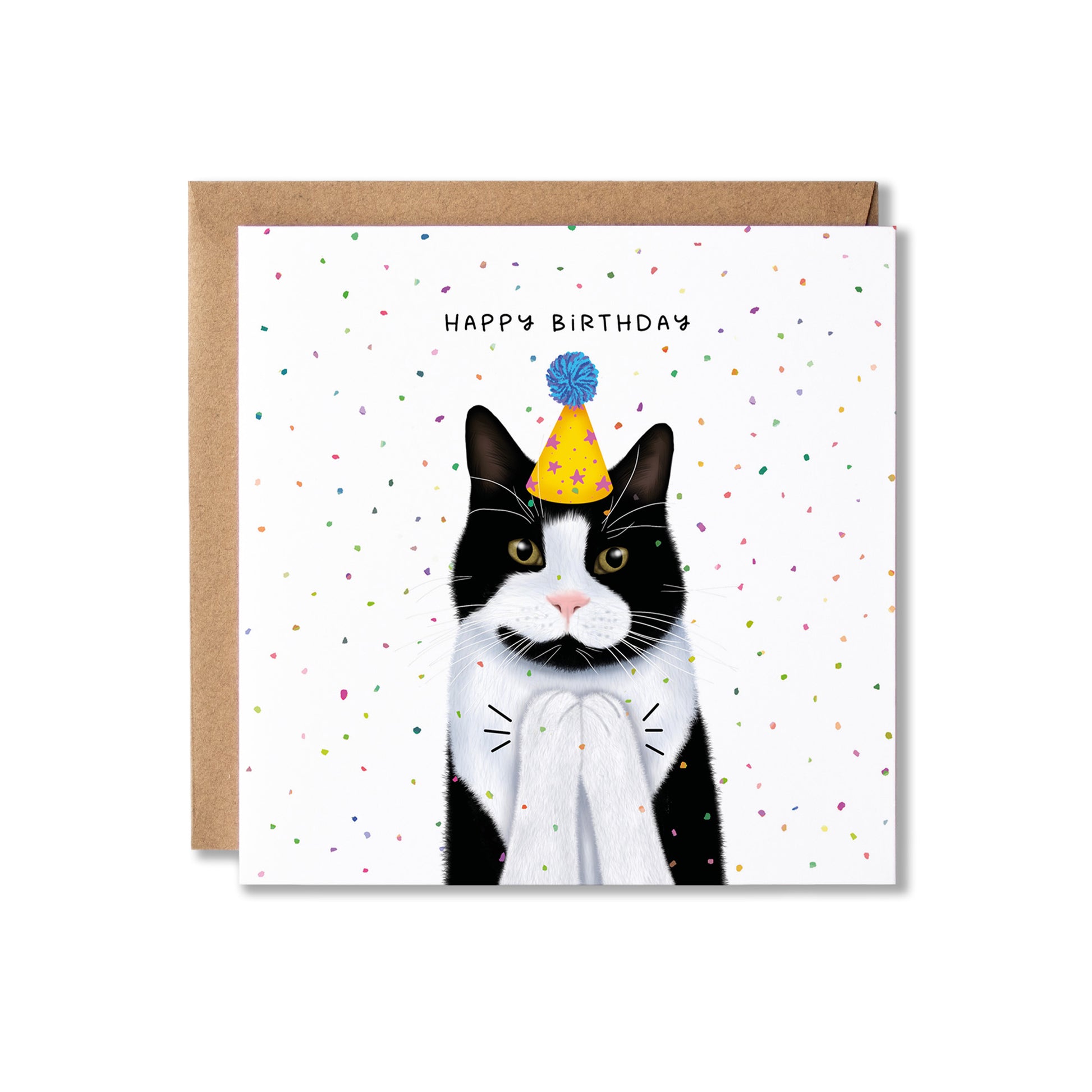 A square birthday card featuring an illustrated black-and-white cat wearing a yellow party hat with a blue pom-pom, clapping, with the words 'HAPPY BIRTHDAY' above it. The card is shown with a brown kraft envelope behind it on a light gray background.