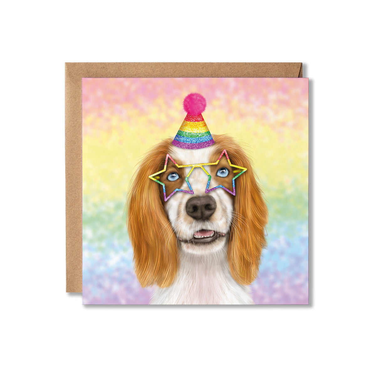 A square greeting card with a brown kraft envelope behind it, featuring a colourful illustration of a Spaniel dog with long tan ears, blue eyes, a rainbow party hat, and star-shaped rainbow glasses against a pastel rainbow background.