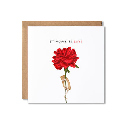 A square greeting card with a kraft paper envelope, featuring a single red rose illustration with a mouse hanging on to the stem and the text 'IT MOUSE BE LOVE' on a white card background.