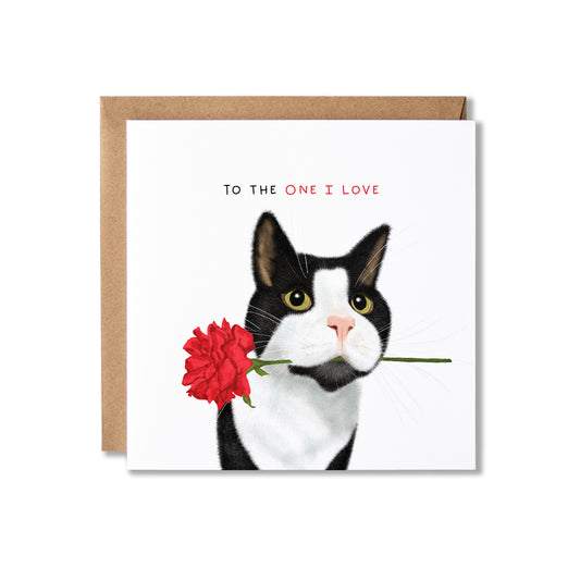 A square greeting card with a kraft envelope behind it, featuring an illustration of a black-and-white cat holding a red flower in its mouth, with the text 'TO THE ONE I LOVE' above.