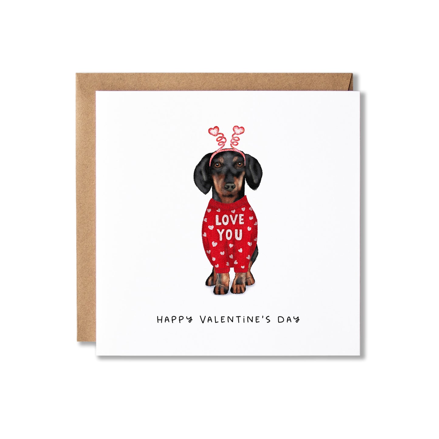 A square Valentine's Day greeting card with a kraft envelope behind it. The card features an illustration of a dachshund wearing a red sweater with white hearts and the words 'LOVE YOU', with 'HAPPY VALENTINE'S DAY' printed below.