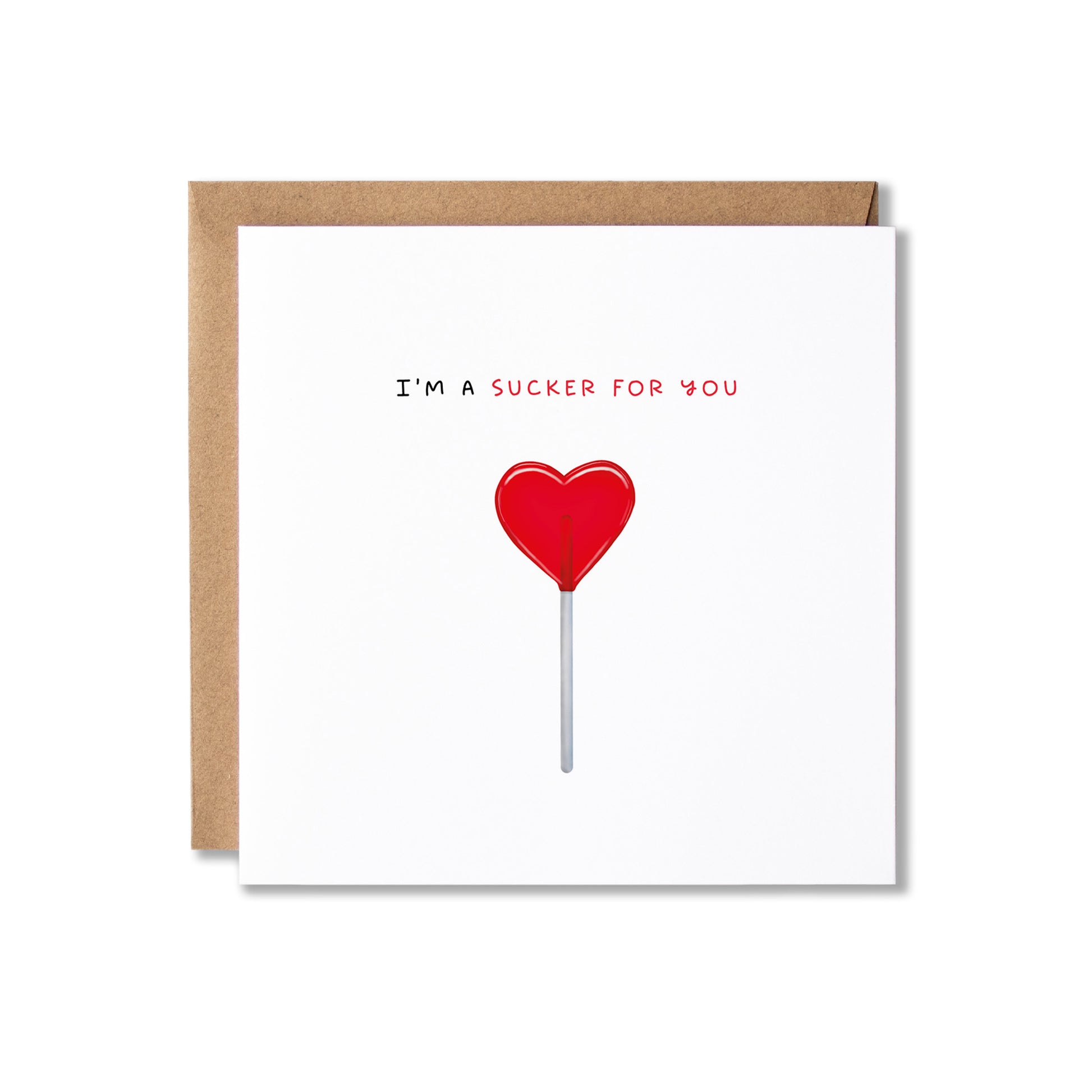 A square white greeting card with a brown kraft envelope behind it, featuring the text 'I'M A SUCKER FOR YOU' above a red heart-shaped lollipop illustration on a white background.