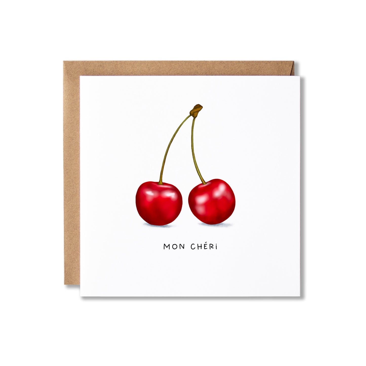 A square white greeting card with an illustration of two red cherries and the text 'MON CHÉRI' below, shown with a brown kraft envelope behind it on a white background.