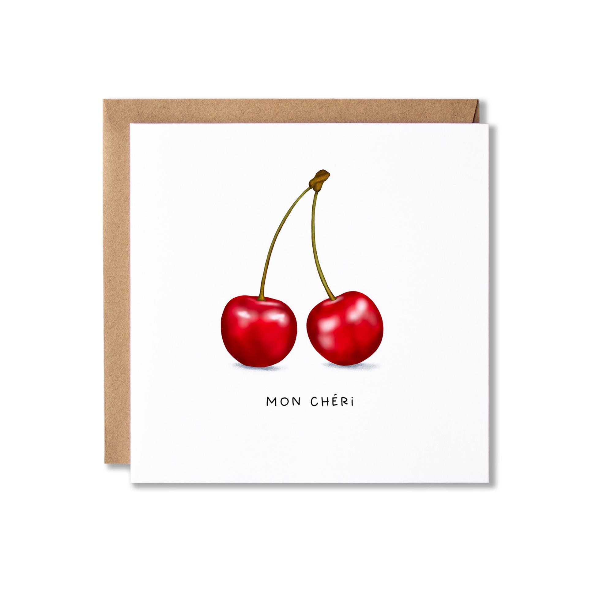 A square white greeting card with an illustration of two red cherries and the text 'MON CHÉRI' below, shown with a brown kraft envelope behind it on a white background.